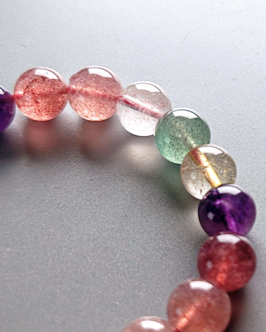 Close-up of a bracelet with multicolored beads on a gray background
