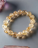 Load image into Gallery viewer, Beaded bracelet with yellow gemstones on a gray surface