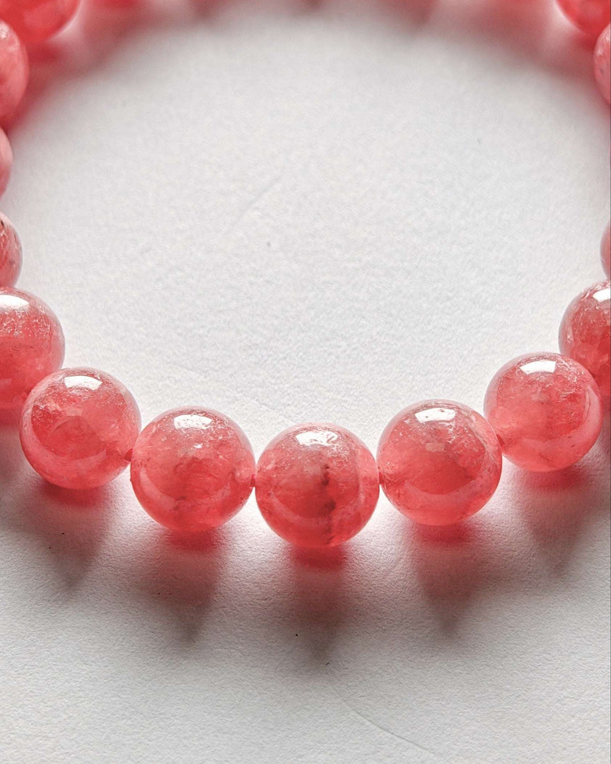 Close-up of a pink beaded bracelet on a white background