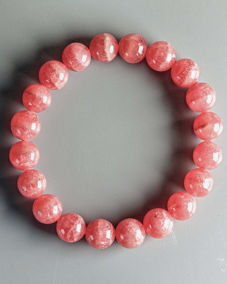 Pink beaded bracelet on a gray background