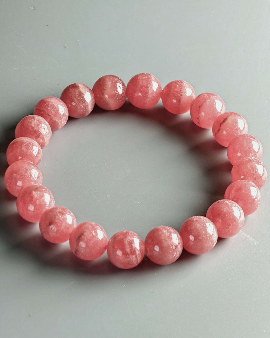 Pink beaded bracelet on a gray background
