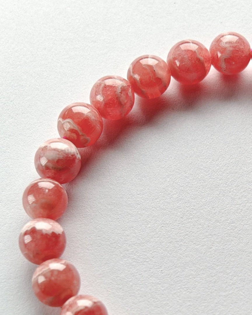 Pink beaded bracelet on a light gray background