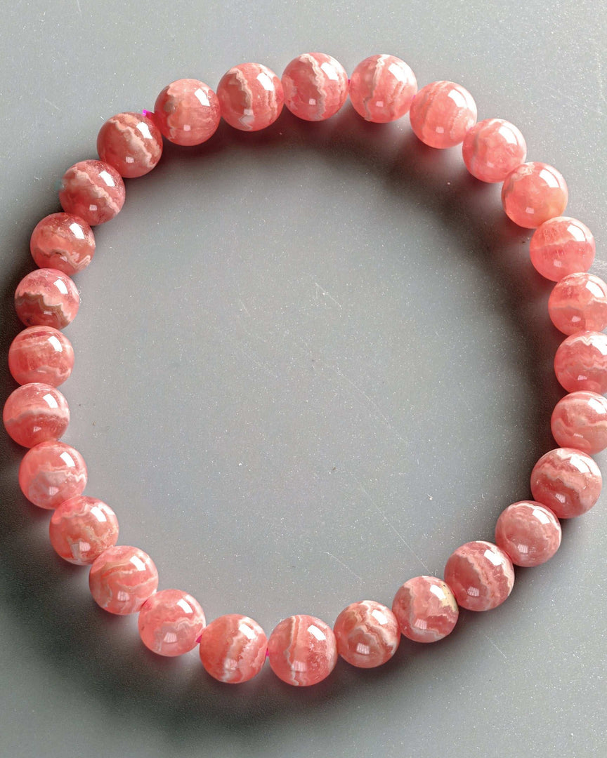 Pink beaded bracelet on a gray background