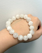 Load image into Gallery viewer, White beaded bracelet on a wrist against a plain background