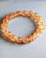 Load image into Gallery viewer, Orange beaded bracelet on a light gray background