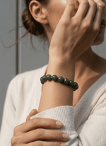 Load image into Gallery viewer, Person wearing a green beaded bracelet on a neutral background