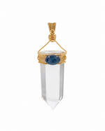 Load image into Gallery viewer, A clear crystal point pendant with a gold wire-wrapped setting and a central oval blue gemstone, shown on a plain white background.