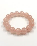 Load image into Gallery viewer, A beaded stretch bracelet made of smooth, translucent light pink round beads, displayed on a clean white background.