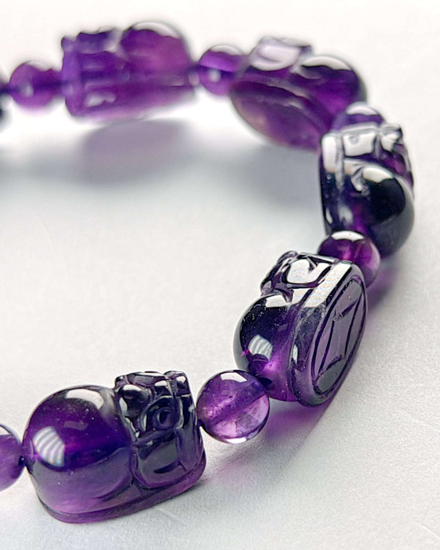 Purple beaded bracelet with silver accents on a white background