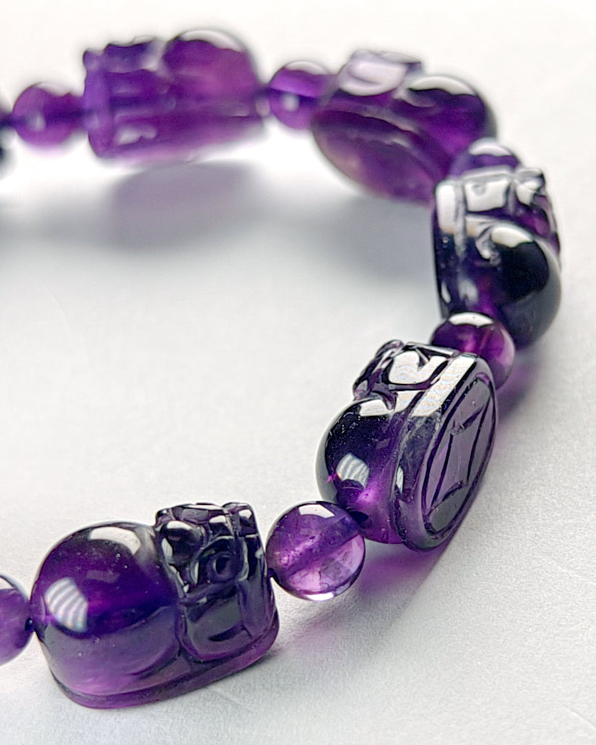 Purple beaded bracelet with silver accents on a white background