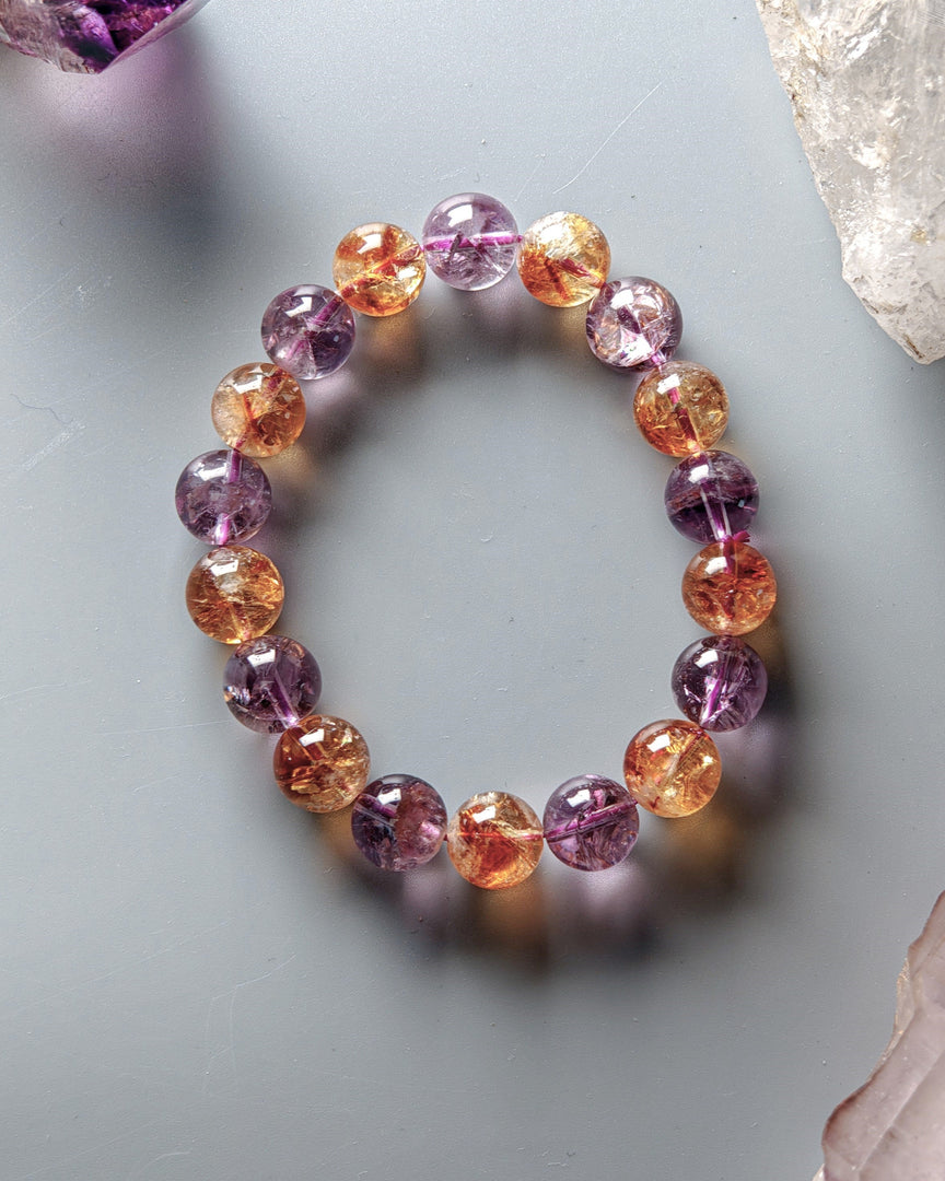 Multicolored beaded bracelet on a light gray background with crystals.