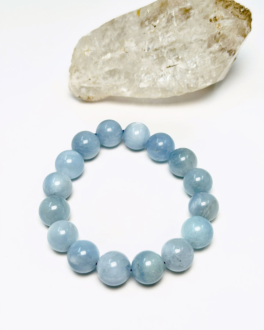 Blue beaded bracelet on a white background with a crystal rock.