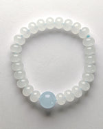 Load image into Gallery viewer, Beaded bracelet with a central light blue bead on a white background