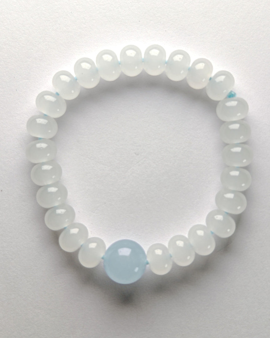 Beaded bracelet with a central light blue bead on a white background