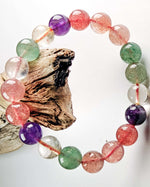 Load image into Gallery viewer, Multicolored beaded bracelet on a white background with a piece of driftwood.
