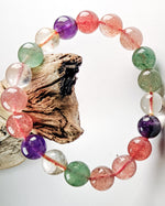 Load image into Gallery viewer, Multicolored beaded bracelet on a white background with a piece of driftwood.

