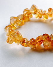 Bracelet made of amber-colored crystal beads on a light background