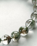 Load image into Gallery viewer, Close-up of Green Phantom Quartz Bracelet (Light Inclusion) on a light gray background