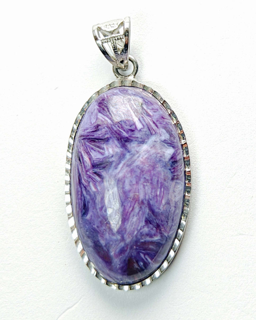 Purple stone pendant with silver frame on white background