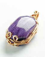 Load image into Gallery viewer, Purple stone pendant with gold wire wrapping on a white background
