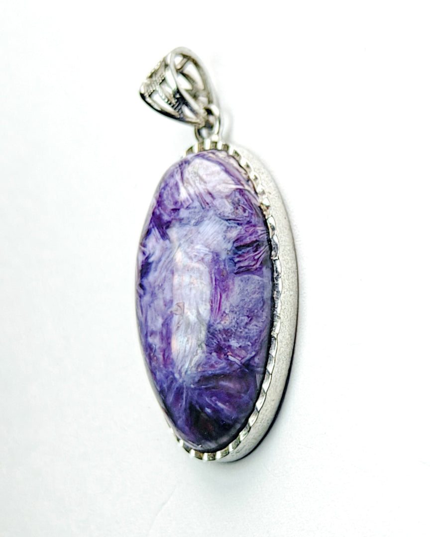 Purple pendant with a silver frame on a white background