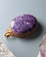 Load image into Gallery viewer, Purple stone pendant with gold frame on a gray background

