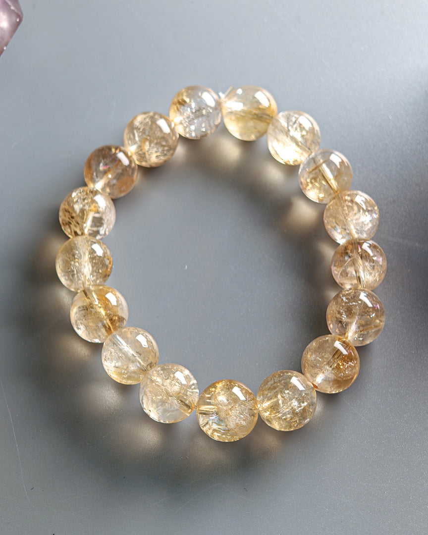Beaded bracelet with yellow gemstones on a gray background