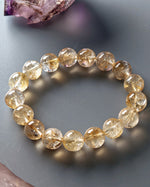 Load image into Gallery viewer, Beaded bracelet with clear and yellow stones on a gray surface
