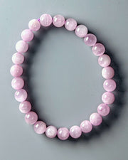 Pink beaded bracelet on a gray background