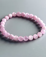 Load image into Gallery viewer, Pink beaded bracelet on a gray background 
