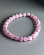 Load image into Gallery viewer, Pink beaded bracelet on a gray background
