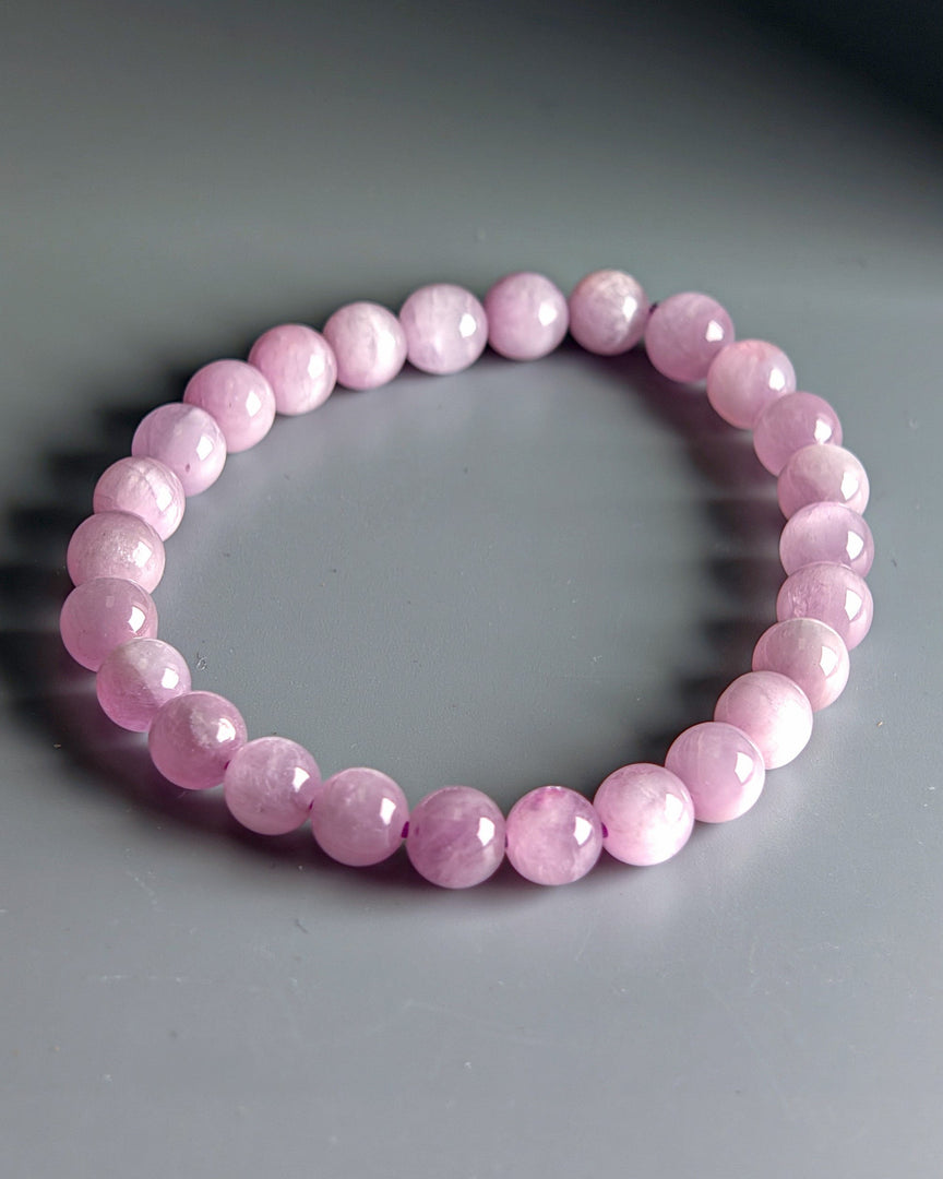 Pink beaded bracelet on a gray background