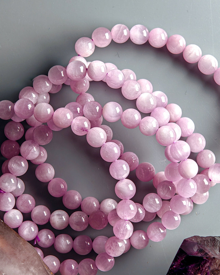 Pink beaded necklace on a light gray background