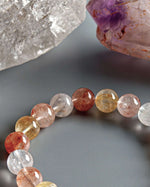 Load image into Gallery viewer, Multicolored gemstone bracelet on a dark surface with a crystal in the background
