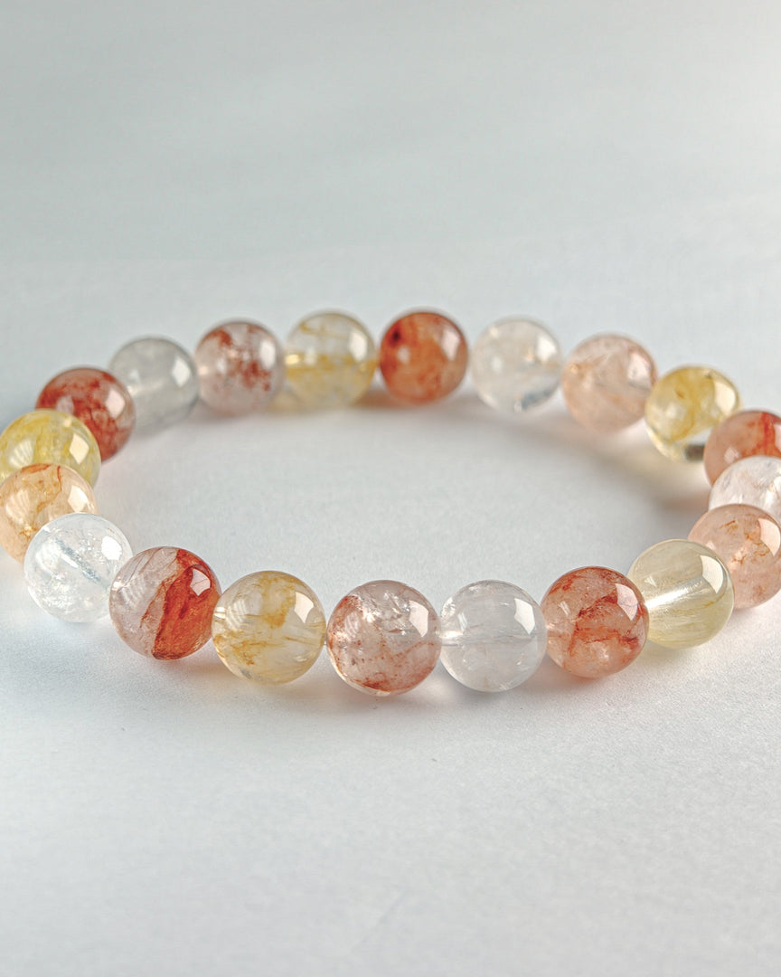 Beaded bracelet with multicolored beads on a light gray background
