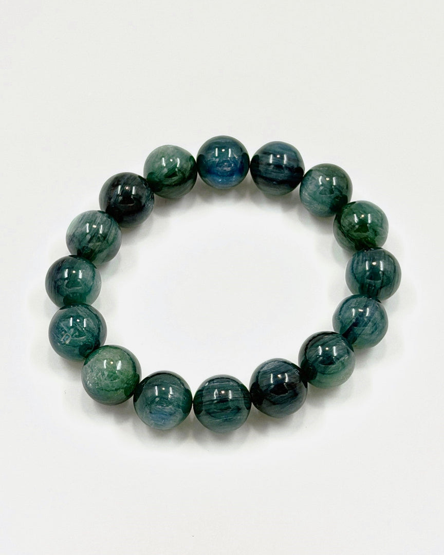 A beaded stretch bracelet made of polished round beads in shades of green and blue with natural marbled patterns, displayed on a clean white background.