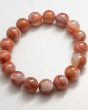 Beaded bracelet with brown and white marbled beads on a white background