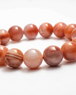 Load image into Gallery viewer, Necklace with round, orange-brown beads on a white background
