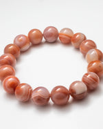 Load image into Gallery viewer, Beaded bracelet with pink and orange marbled beads on a white background
