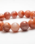Load image into Gallery viewer, Necklace with round, orange-brown beads on a white background
