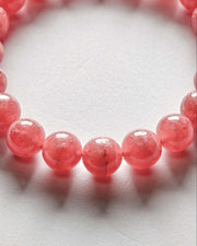 Close-up of a pink beaded bracelet on a white background