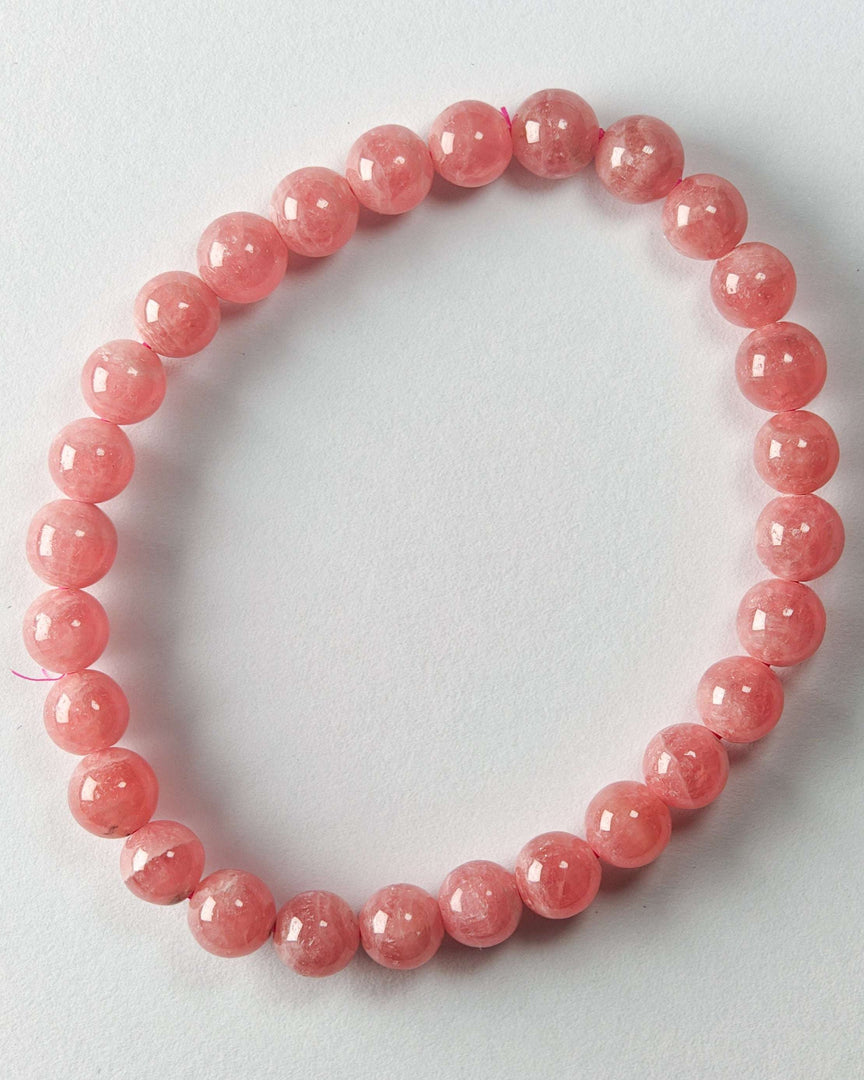 Pink beaded bracelet on a light gray background