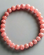 Load image into Gallery viewer, Pink beaded bracelet on a gray background
