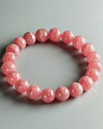 Load image into Gallery viewer, Pink beaded bracelet on a gray background
