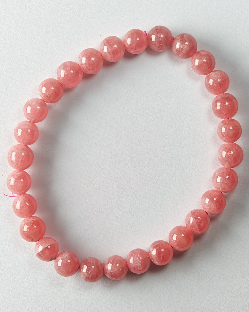Pink beaded bracelet on a light gray background