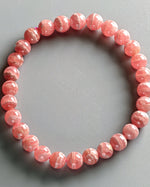 Load image into Gallery viewer, Pink beaded bracelet on a gray background
