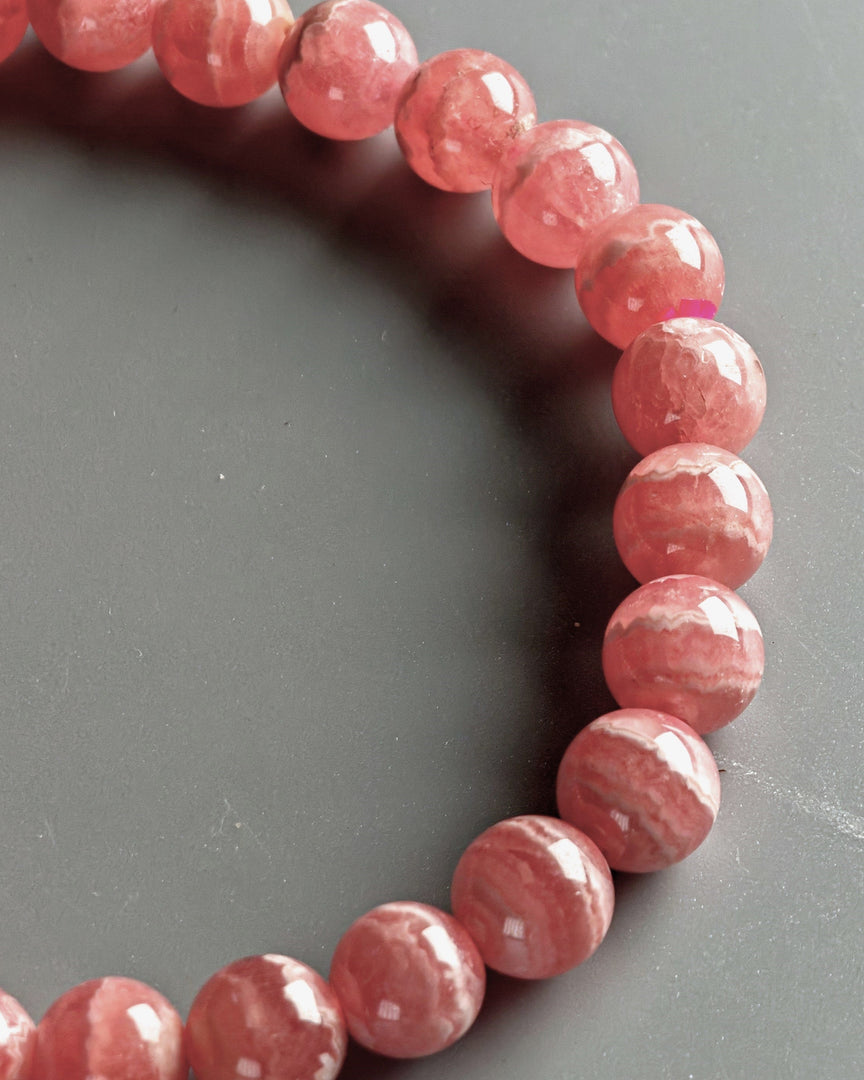 Pink beaded bracelet on a gray background