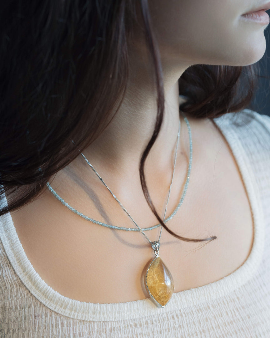 golden rutilated quartz pendant in silver setting