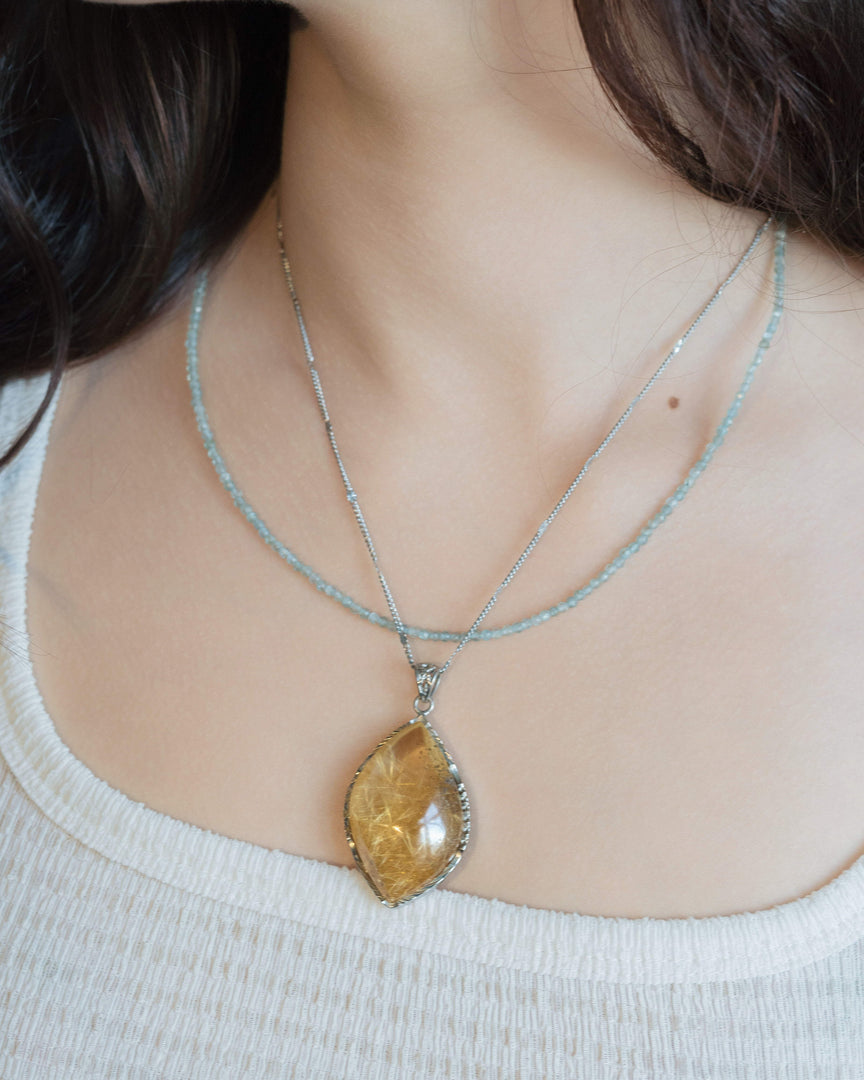 golden rutilated quartz pendant in silver setting