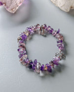 Load image into Gallery viewer, Purple beaded bracelet on a light gray surface

